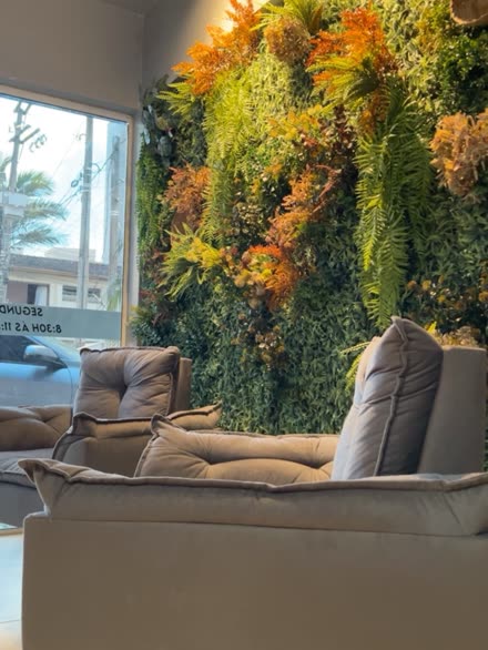 Recepção da ContaKE, com parede de plantas e poltronas